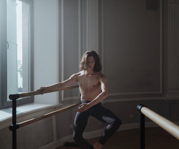 Man performing a controlled strength exercise in a bright, clean space.